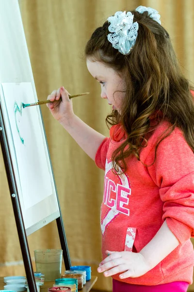 Liten flicka 4-5 år gammal ritar med en borste — Stockfoto