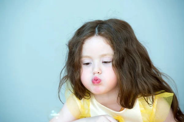 Menina com cabelo longo soprando bolhas — Fotografia de Stock