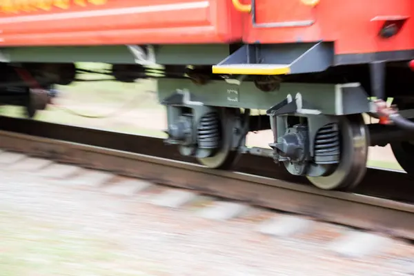 Rodas borradas de movimento de um carro de trem em movimento close-up. Rodas do carro ferroviário em movimento — Fotografia de Stock