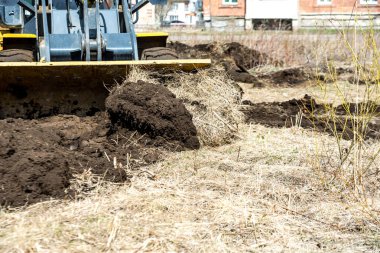 buldozer zemin iter, traktör toprak bir yumru iter, inşaat için alan hazırlanıyor