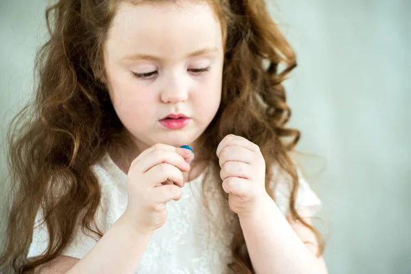 En liten flicka lär sig att använda färgglada spela degen. Närbild. — Stockfoto