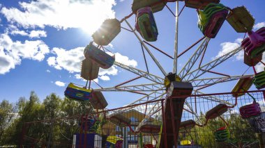 Atlıkarınca bulutlarla bir golby gökyüzünün arka planında dönüyor.