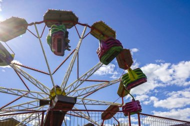 Atlıkarınca bulutlarla bir golby gökyüzünün arka planında dönüyor.