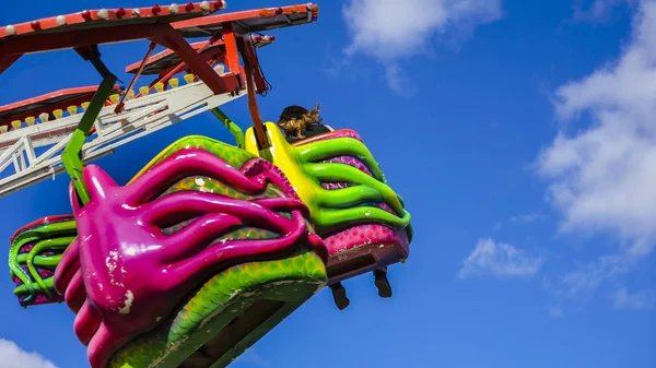 Multi-colored swings against the blue sky. The multi-colored roundabout turns on a background of the blue sky. — Stock Photo, Image