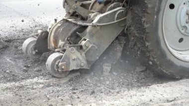 Yol frezeleme makinesi eski asfaltı keser. Yol tamiri. Yol yüzeyinin imha edilmesi. Kesici bir asfalt tabakası keser. Yavaş hareket. Taş parçaları ayrı uçarlar. Close.
