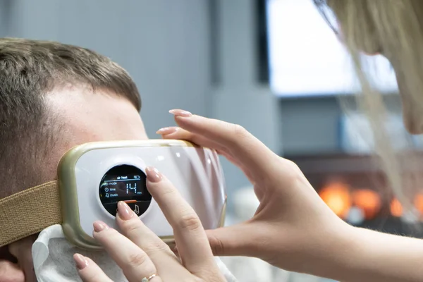 Rahatlayın ve masaj, erkek kavramı üzerinde elektrikli göz masajı, closeup. Programlama.