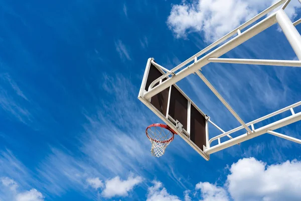 Basquetebol backboard com um anel na rua e céu azul — Fotografia de Stock