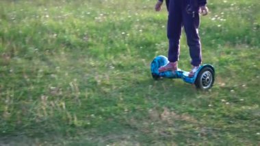 Giroskuter köyde. Günbatımı. Kız genç çim, güneş ışığı, yaz üzerinde bir gyro sürme