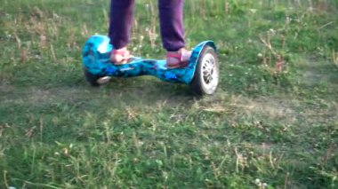 Giroskuter köyde. Günbatımı. Kız genç çim, güneş ışığı, yaz üzerinde bir gyro sürme