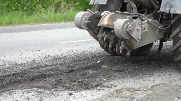 道路铣床切割旧沥青 道路维修 破坏路面 切割机切割一层沥青 一块石头飞散了 — 图库视频影像
