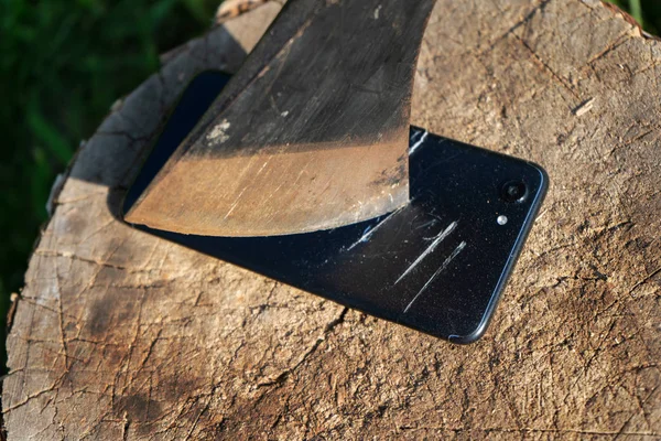 Destroy innovation. Vandalism act. Smartphone on the stump. Smartphone near the ax. — Stock Photo, Image