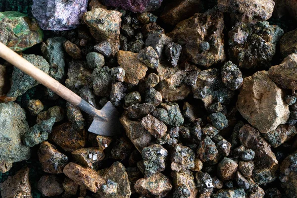 Mining. A miniature shovel and pieces of minerals with crystals. — Stock Photo, Image