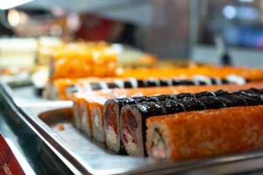 Cam büfede bir sürü suşi rulosu var. Japonya geleneksel gıda.