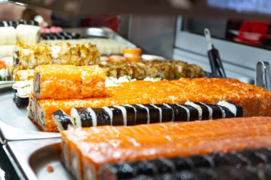 Cam büfede bir sürü suşi rulosu var. Japonya geleneksel gıda.