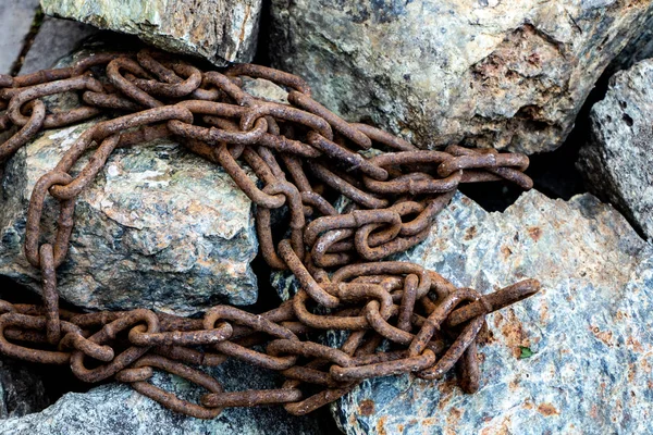 Rusty łańcuch na szare kamienie. Symbol pracy niewolniczej — Zdjęcie stockowe