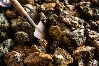 Madenci -liği. Minyatür bir kürek ve kristaller ile mineraller parçaları.