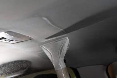 Kuru Temizleme salonu araçları. İşçi arabada yıkama Vakum kullanır.