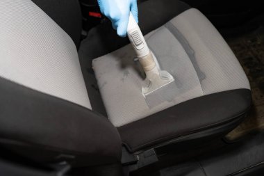 Kuru Temizleme salonu araçları. İşçi arabada yıkama Vakum kullanır.