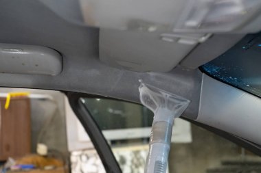 Kuru Temizleme salonu araçları. İşçi arabada yıkama Vakum kullanır.