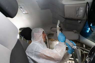 Chelyabinsk Region, Rusya-Temmuz 2019. Kuru Temizleme salonu araçları. Arabada elektrikli süpürge kullanan erkek işçisi