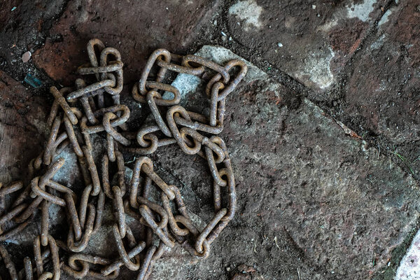 Rusty chain on the brickwork. The symbol of slave labor