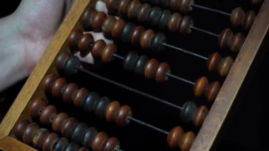 Adam vintage eski abaküs kullanır. Vintage ahşap banknotlar yakın çekim erkek el.