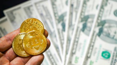 Bitcoins dolar arka planda. olden Bitcoins. Yeni sanal para. yüz dolarlık banknotlar üzerinde bitcoin sembolik sikkeler. Bir dolar için döviz bitcoin nakit.