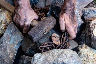 Bir köle ellerini serbest bırakmak için bir girişim. Köle işçiliğinin sembolü. Eller zincire