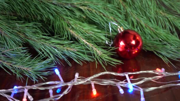 Weihnachtskugeldekor Auf Einem Holzbrett Mit Tannenzweigen Kopierraum — Stockvideo