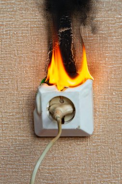 Yanan elektrik kabloları ve elektrik prizi. Hatalı kablolama yangına neden olur. Kötü eski kablolama elektrik prizinde yangına neden olur.