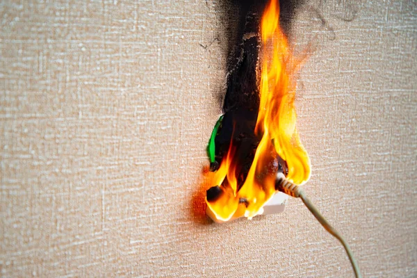 Burning electrical wiring and electrical outlet. Faulty wiring causes fires. Poor old wiring causes a fire in the electrical outlet. — Stock Photo, Image