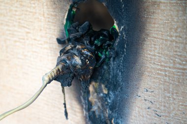 Yanmış elektrik prizi. Güç kaynağının erimiş ve yanmış plastik soketi