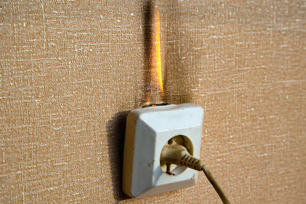 Burning electrical wiring and electrical outlet. Faulty wiring causes fires. Poor old wiring causes a fire in the electrical outlet. — Stock Photo, Image