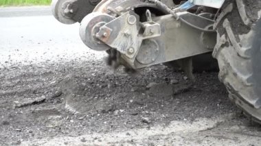 Yol frezeleme makinesi eski asfalt keser. Yol tamiri. Yol yüzeyinin yok edilmesi. Kesici bir asfalt tabakası keser. Taş parçaları birbirinden ayrı uçar. Close