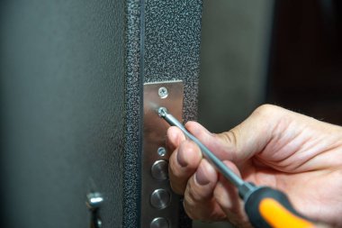 Bir adam kapı kilidini tamir eder. Close.