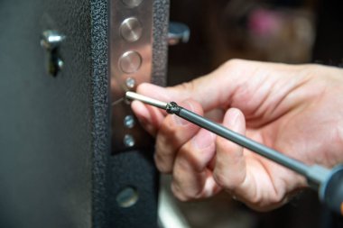 Bir adam kapı kilidini tamir eder. Close.