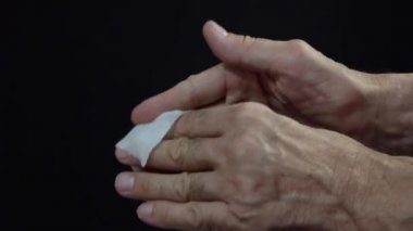 El dezenfeksiyonu için antibakteriyel ıslak mendil kullanımı. Karanlık bir geçmişi olan yaşlı bir adamın elleri..