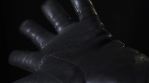Gouden Bitcoins vallen in een hand met een zwarte leren handschoen — Stockvideo