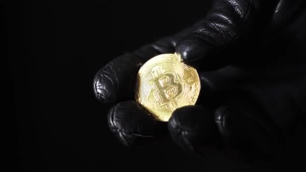 Monety Bitcoins zbliżenie na ciemnym tle. Czarne skórzane rękawice na rękach. — Wideo stockowe