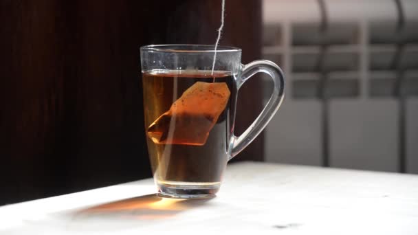 Tea Zsák Forró Vízben Nap Ragyogó Sugarai Egy Átlátszó Csészén — Stock videók