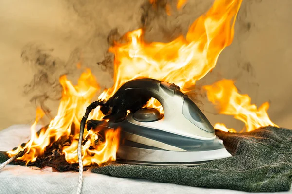 They forgot to turn off the electric iron for ironing clothes. Careless handling of electrical household appliances can cause a fire. The house started a household fire. — Stock Photo, Image