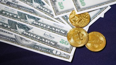 Bitcoins dolar arka planda. olden Bitcoins. Yeni sanal para. yüz dolarlık banknotlar üzerinde bitcoin sembolik sikkeler. Bir dolar için döviz bitcoin nakit.