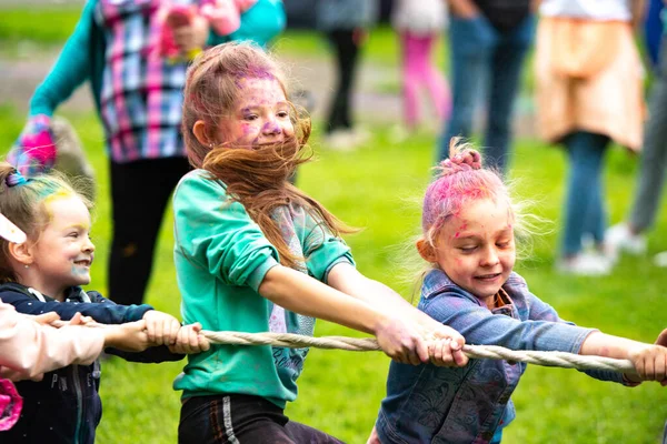 Chelyabinsk Region, Russia - July 2019. Children of different nationalities are friends at the festival of colors. Tug of war. Children are passionate about the game. Vivid emotions on children's face — Stock Photo, Image