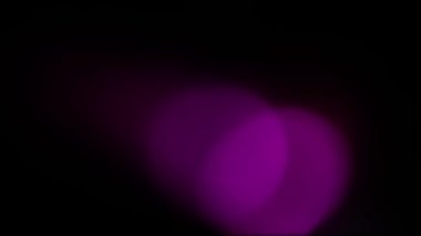 Koyu bir arka planda parlak renkler yanıp sönüyor. Işık, yanıp sönen ışıkların bokeh 'ini iletir. Yumuşak renkli ışık sızıntısı. Hızlı ışık taşması.