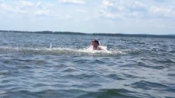 Mężczyzna pływa podnosząc spray z wodą.. — Wideo stockowe