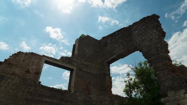 Ruïneerde muur op een achtergrond van witte bewegende wolken. Blauwe lucht. Bakstenen muren — Stockvideo