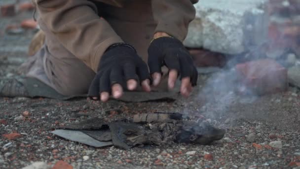 Le SDF se réchauffe les mains. Mains en gants déchirés noirs Gros plan. Scène post-apocalypse — Video