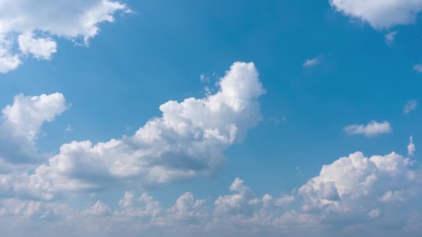 Les nuages se déplacent rapidement contre un ciel bleu par une journée ensoleillée. Nuages blancs de neige tourbillonnants contre le ciel bleu — Video