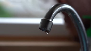 Mutfak mikserindeki eski musluk sızdırıyor. Musluk suyu damlıyor. Gün ışığı makro fotoğrafçılık