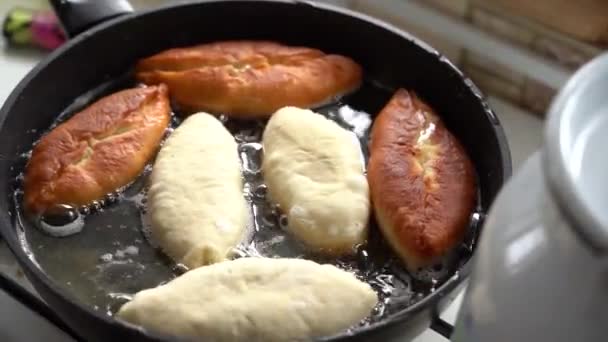 Friggere le torte in olio bollente. Cucina casalinga. Scena di vita reale. Primo piano. Luce diurna dalla finestra — Video Stock